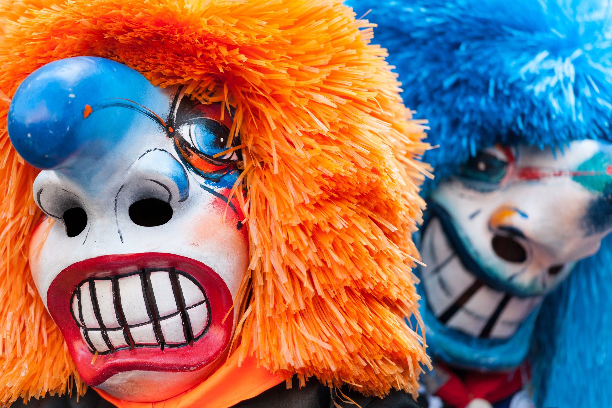 Nahaufnahme von zwei Clowns mit großen Masken