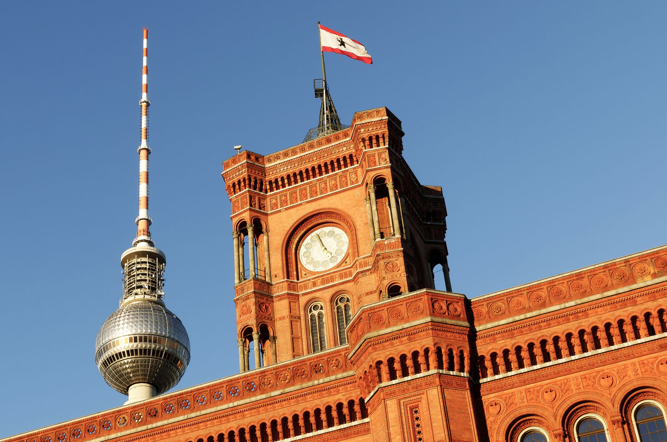 Nahaufnahme des Roten Rathauses in Berlin mit Fernsehturm im Hintergrund
