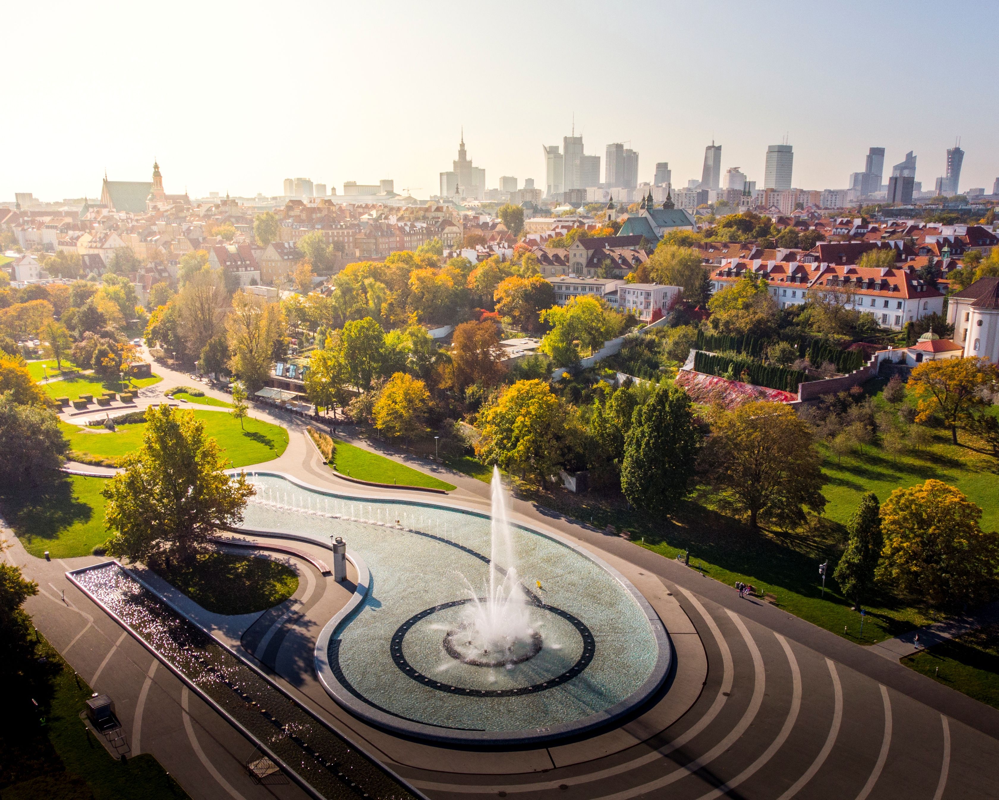 Springbrunnen in Warschau bei Tageslicht mit klaren Wasserstrahlen und umgebender Parklandschaft.