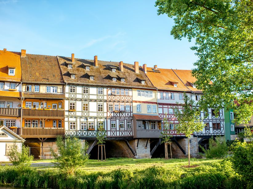 Blick auf die historische Krämerbrücke in Erfurt mit dicht aneinandergereihten Fachwerkhäusern über dem Fluss Gera