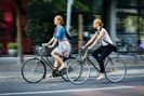 Zwei Frauen radeln durch die Stadt