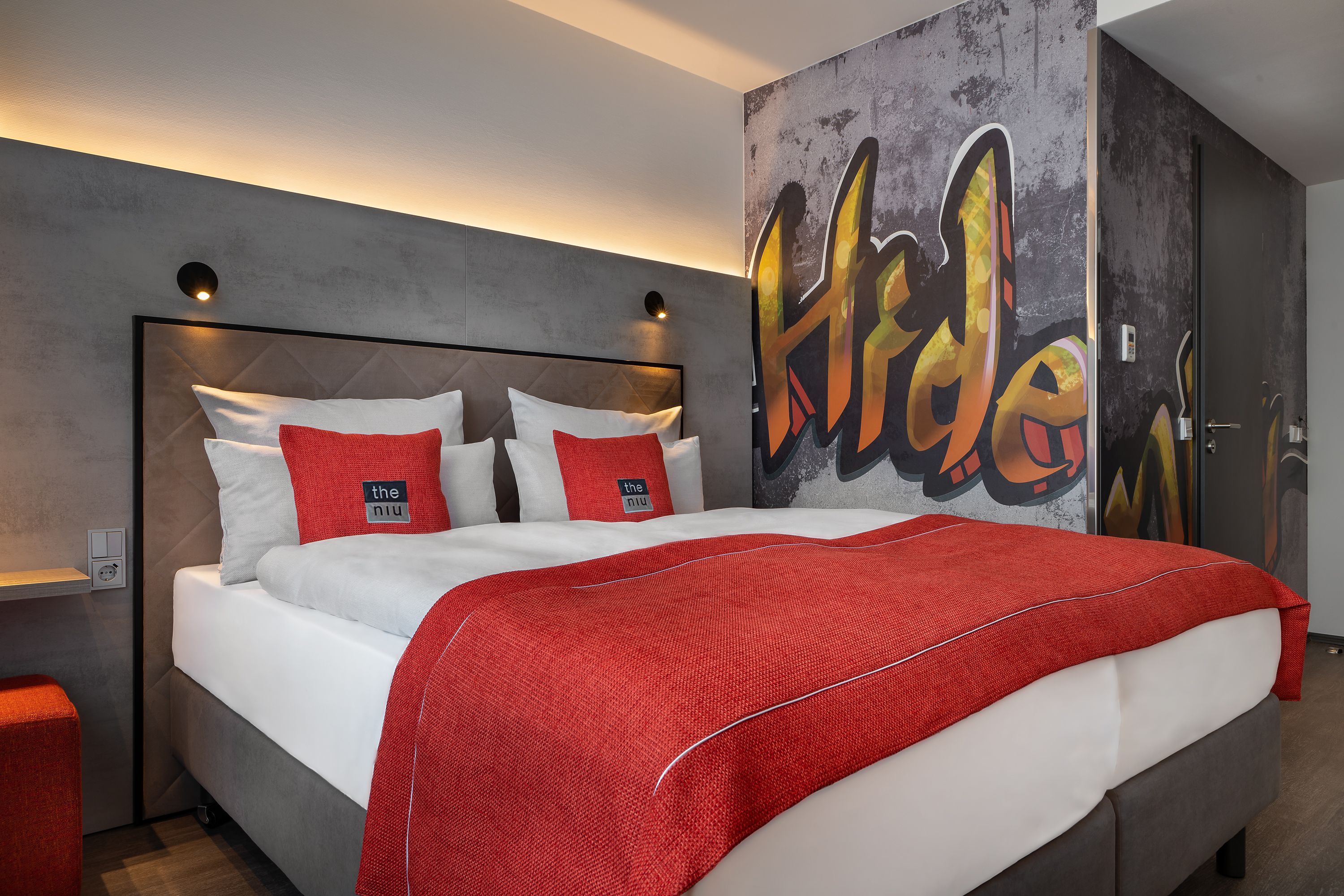 Einladendes Doppelzimmer im Hotel the niu Hide Berlin mit farbenfroher Einrichtung und urbanem Design.