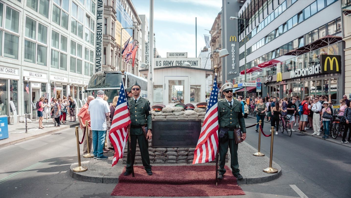 Soldaten mit USA Flagge am Checkpoint Charlie.