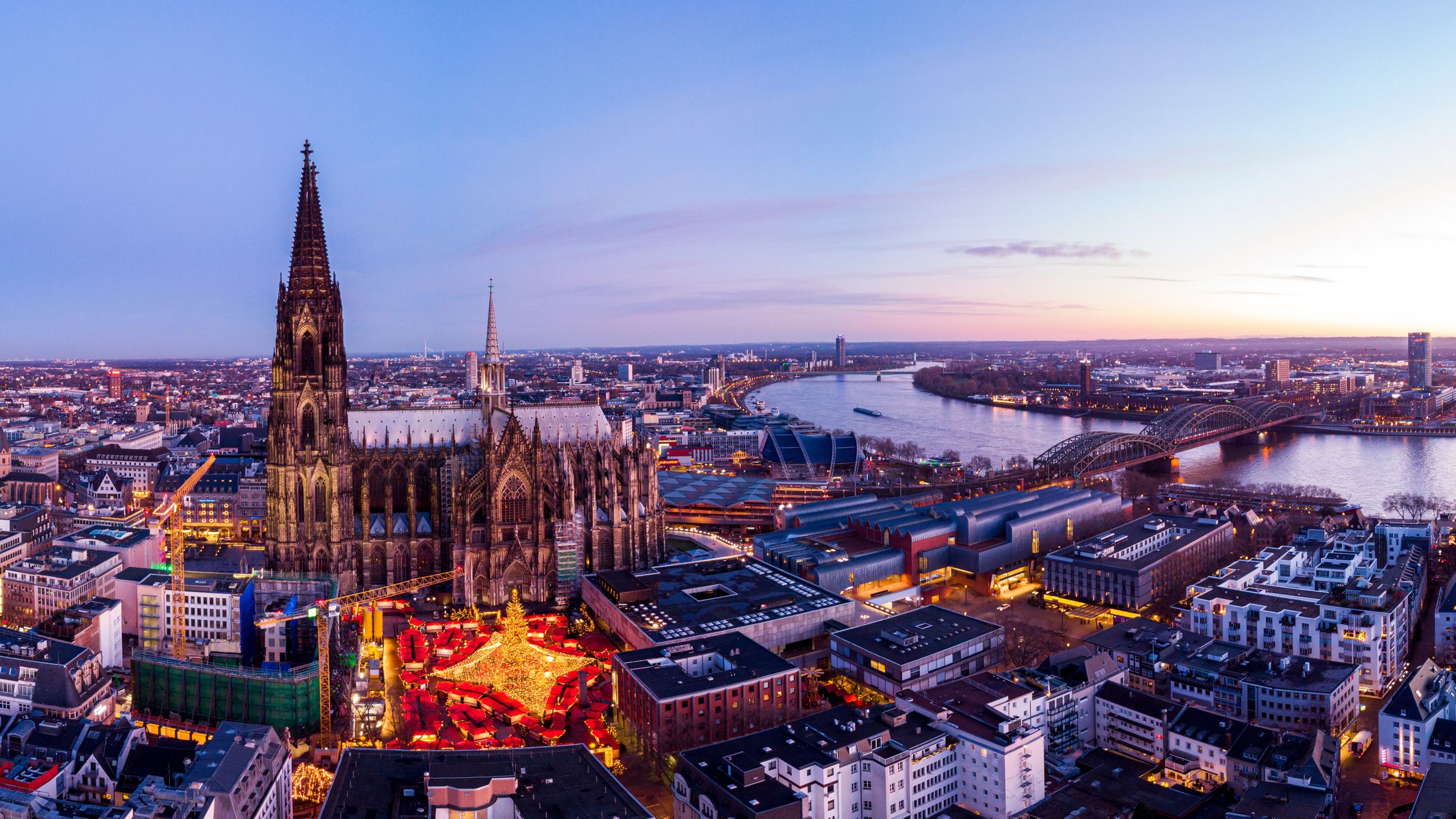 Panorama Ansicht über die Kölner Altstadt und den Weihnachtsmarkt vor dem Kölner Dom bei Dämmerung