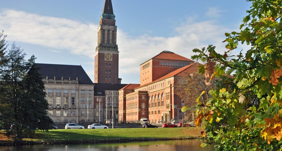 Das Kieler Rathaus im Hintergrund, ein herbstlicher Baum im Vordergrund - BAHNHIT.DE, © getty
