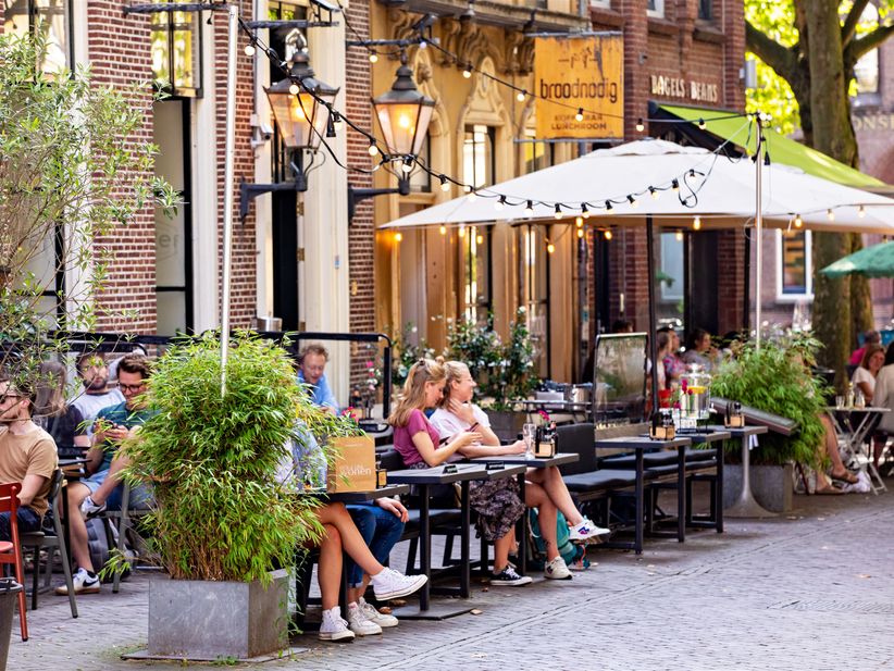 Menschen sitzen draußen im Cafe in der Mariaplaats in Utrecht