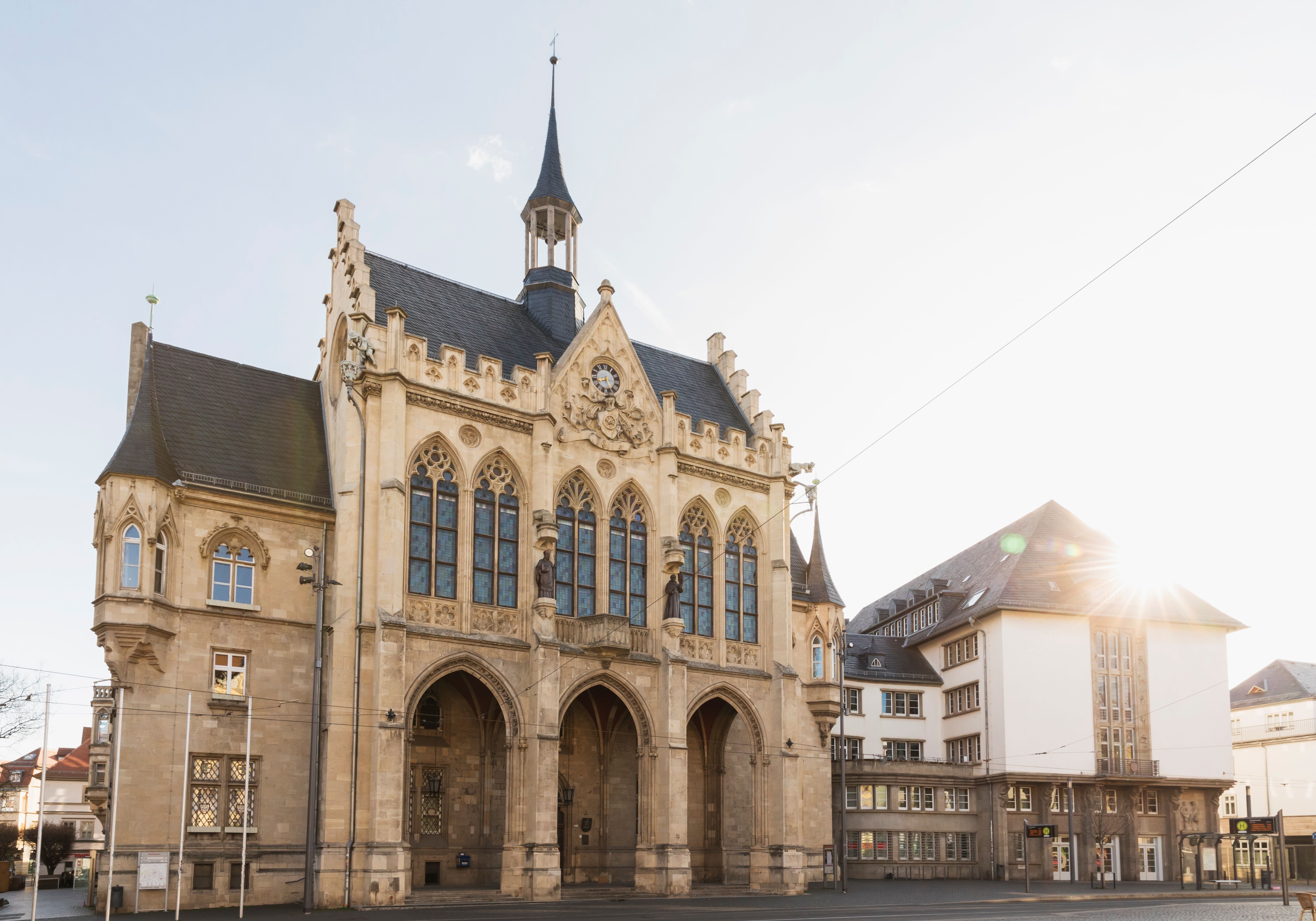 Das neugotische Rathaus von Erfurt bei Tageslicht mit seiner reich verzierten Fassade, Blick auf den Haupteingang am Fischmarkt.