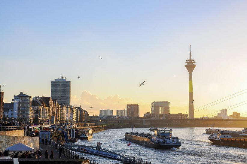 Blick auf die Uferpromenade und den Rhein mit Rheinturm im Hintergrund