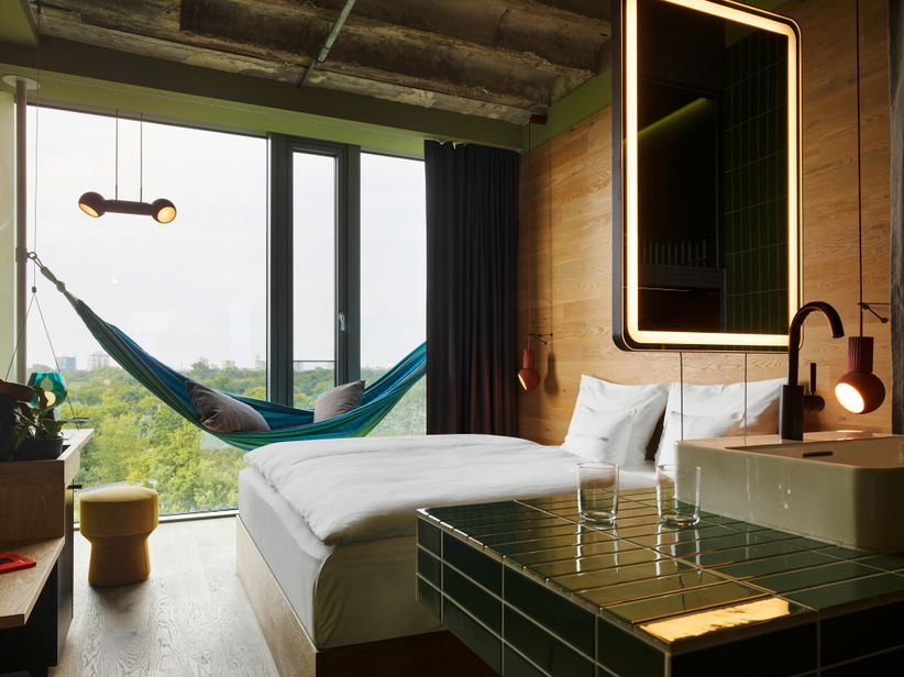 Modern eingerichtetes Zimmer mit viel Holz und naturtönen im 25hours Bikini Hotel mit Blick auf einen Park