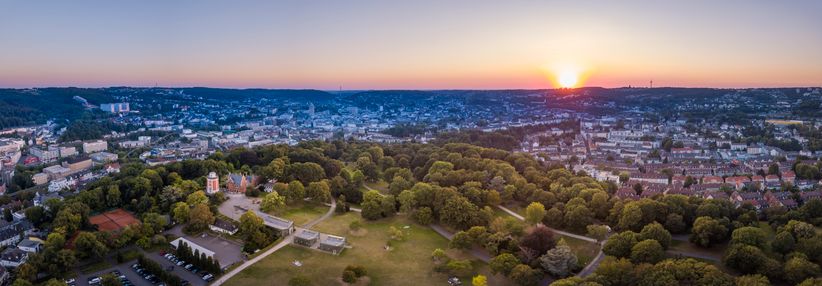 Panoramablick auf Wuppertal mit einem großen Park bei Sonnenuntergang