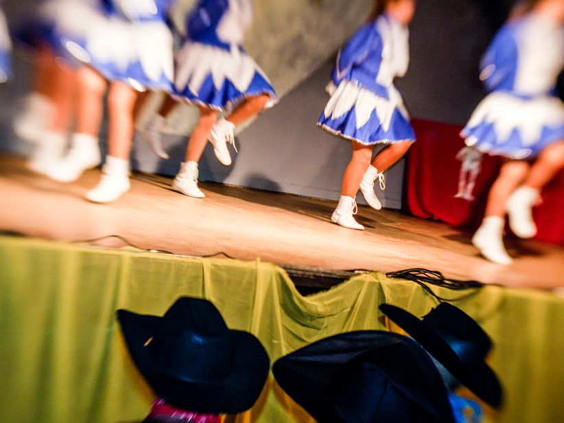 Nahaufnahme einer Karnevalssitzung mit Funkenmariechen Tänzerinnen im Hintergrund