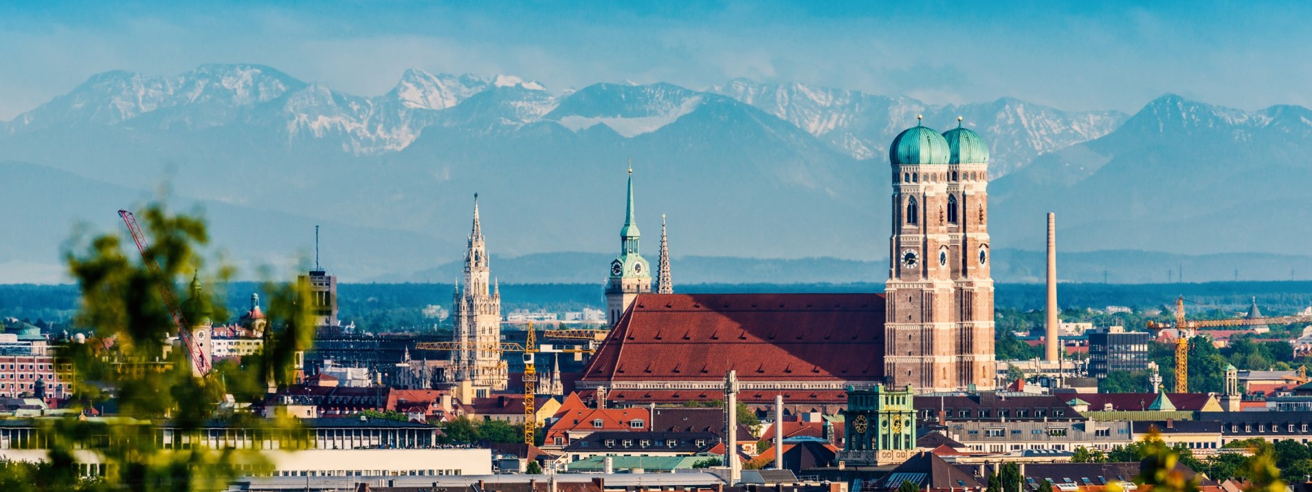 Blick auf die Alpen über den Dächern von München - BAHNHIT.DE, © getty, Foto: jotily