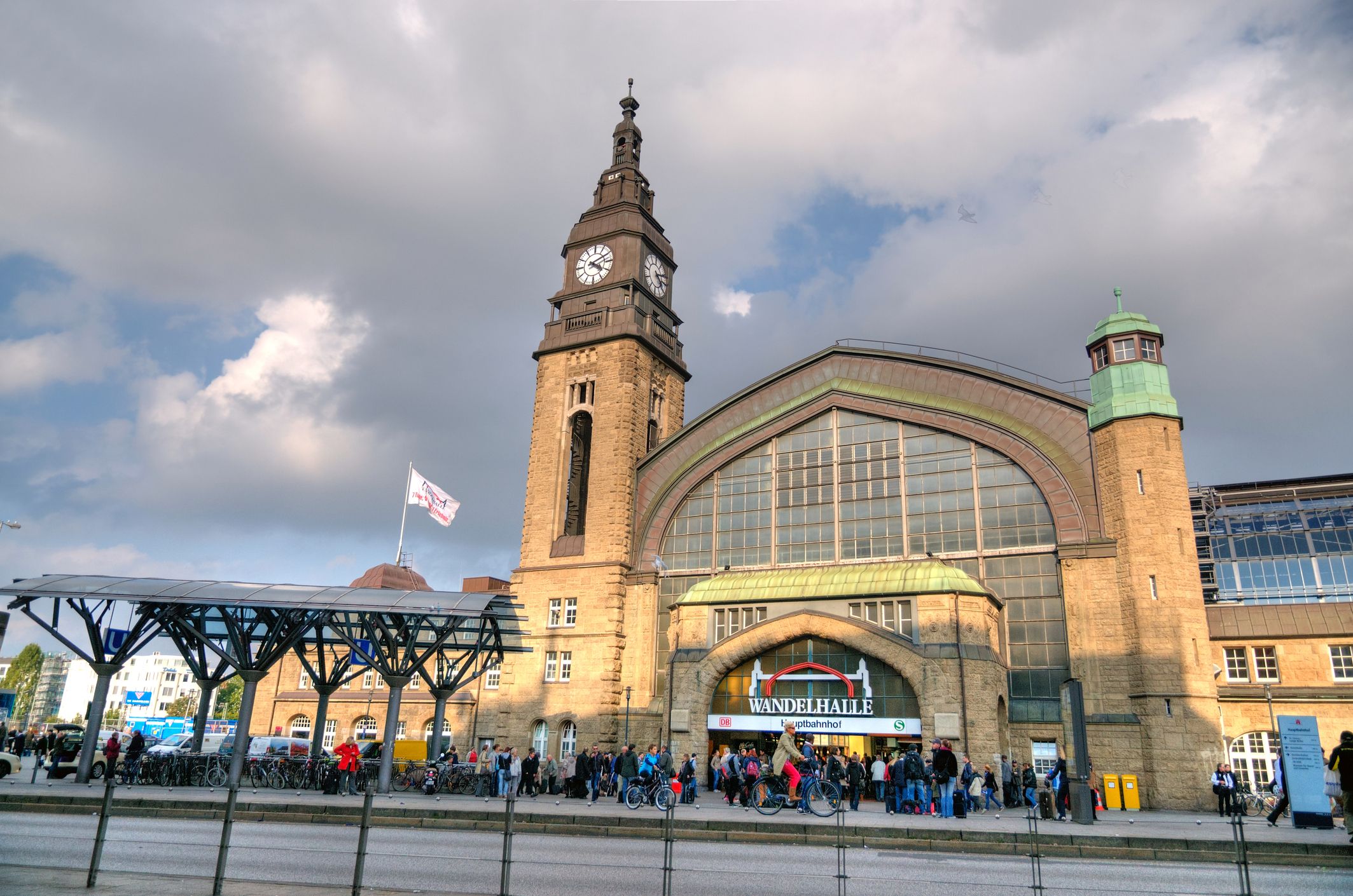 Historische Außenfassade des Hamburger Hauptbahnhofs mit dem markanten quadratischen Uhrturm und der prachtvollen Architektur im Stil der Neorenaissance bei Tageslicht.