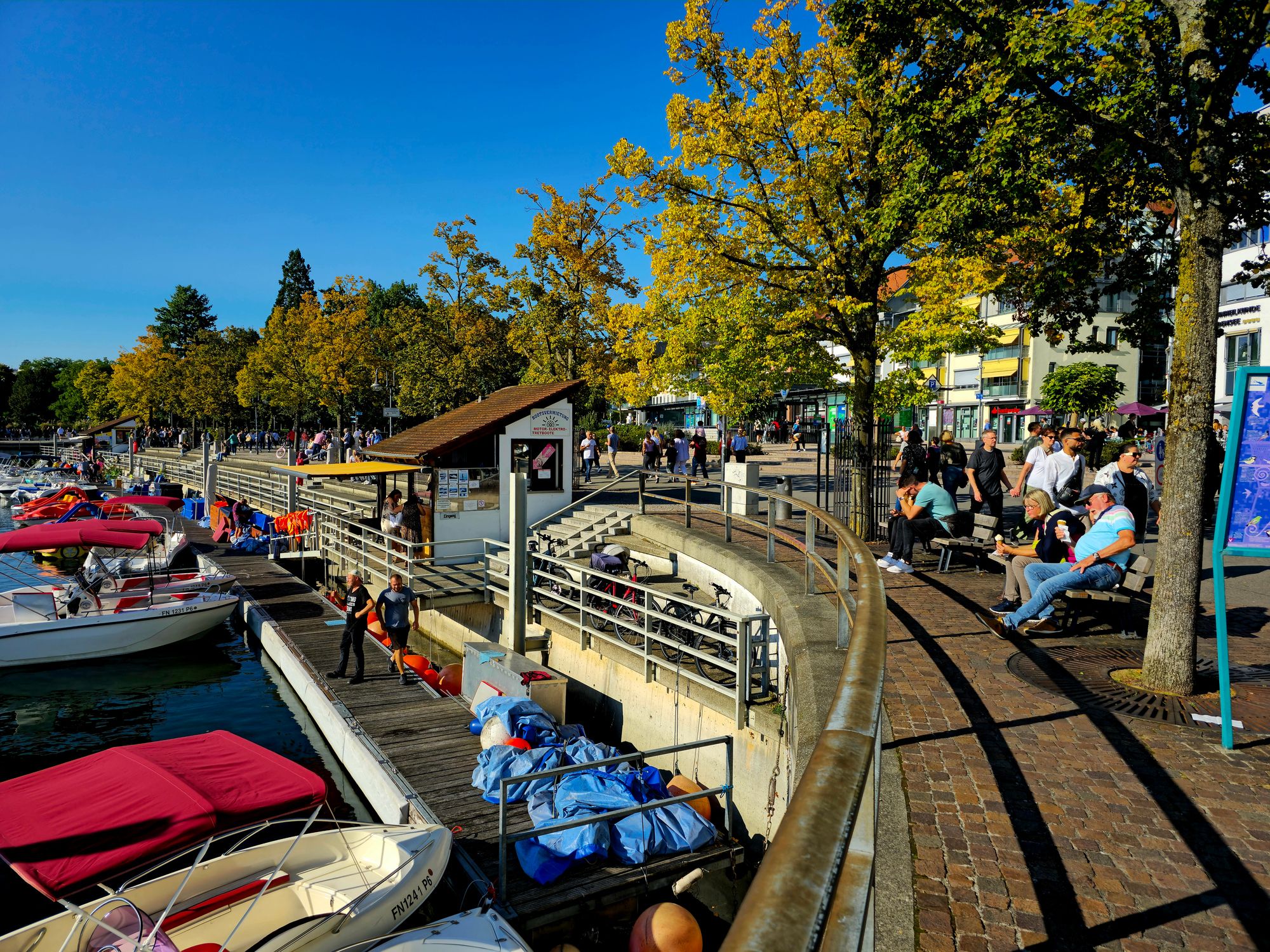 Promenade in Friedrichshafen mit Menschen.