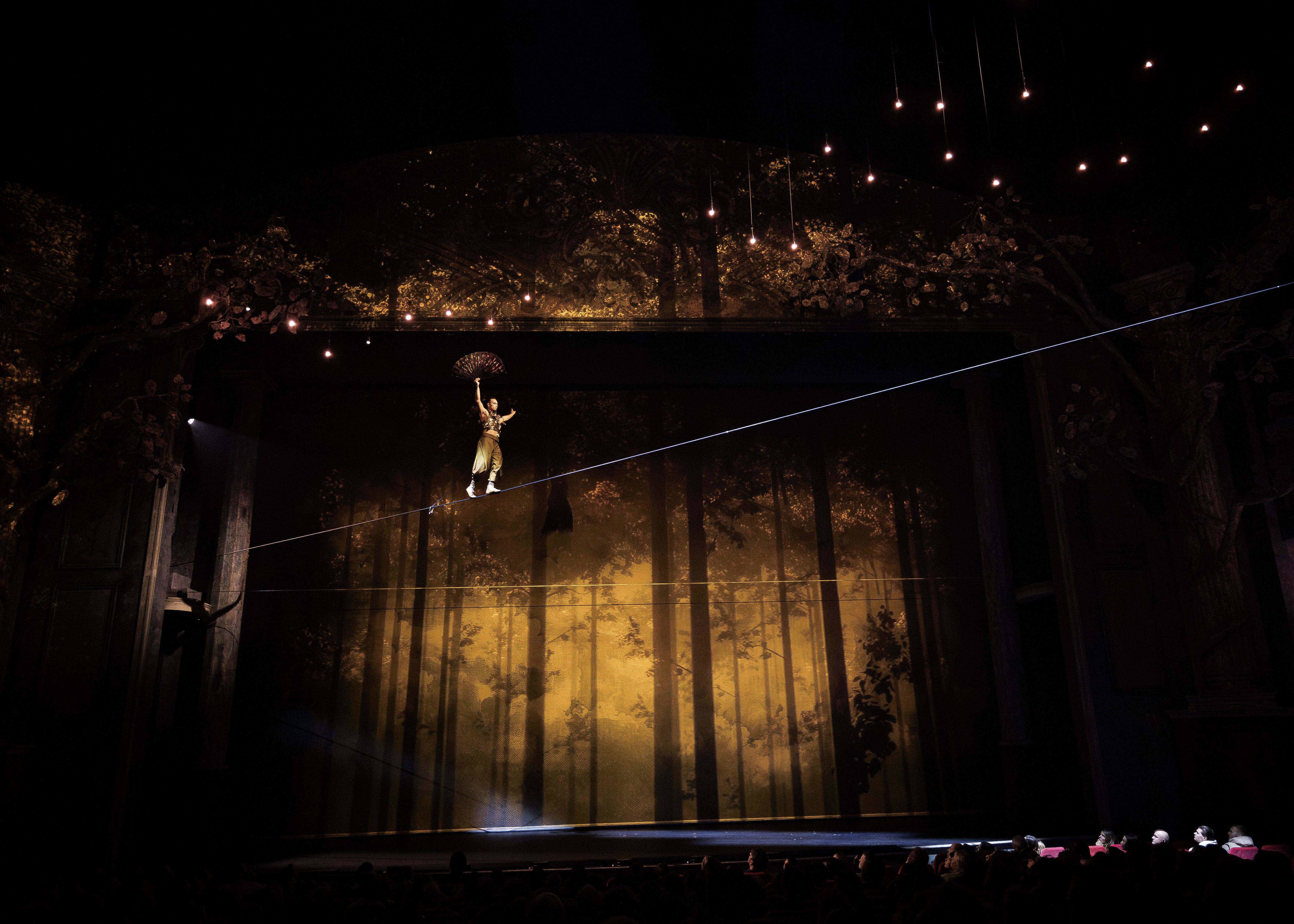 Szenenbild ein Mann balanciert auf dem Hochseil über die Bühne