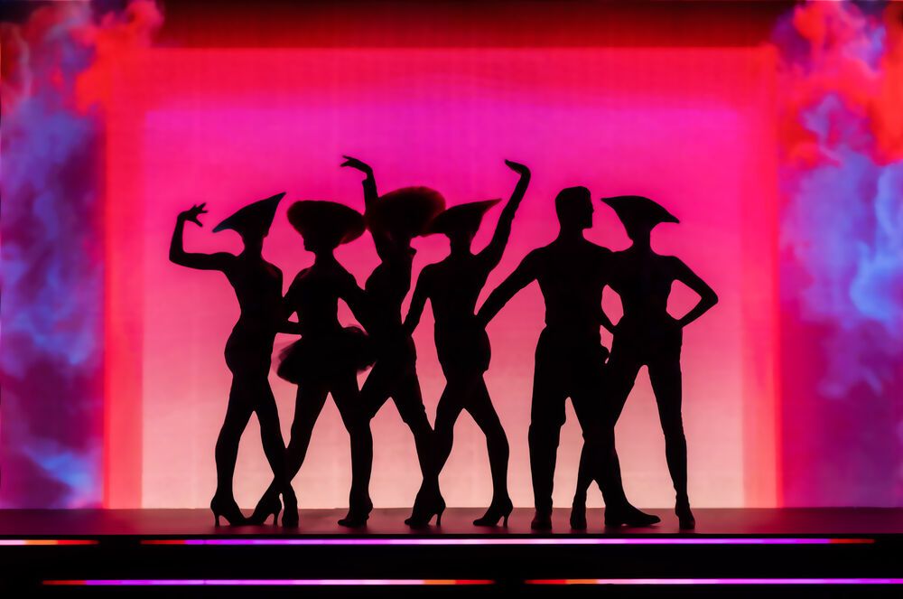 Schatten von Personen vor einem pinken Licht auf der Bühne