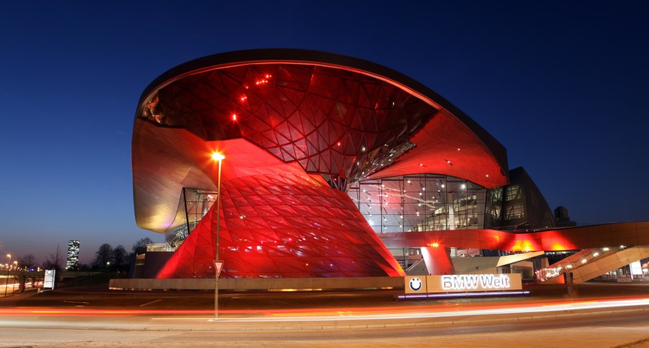 Die BMW Welt rot beleuchtet bei Nacht - BAHNHIT.DE, © München Tourismus, Foto: S. Müller