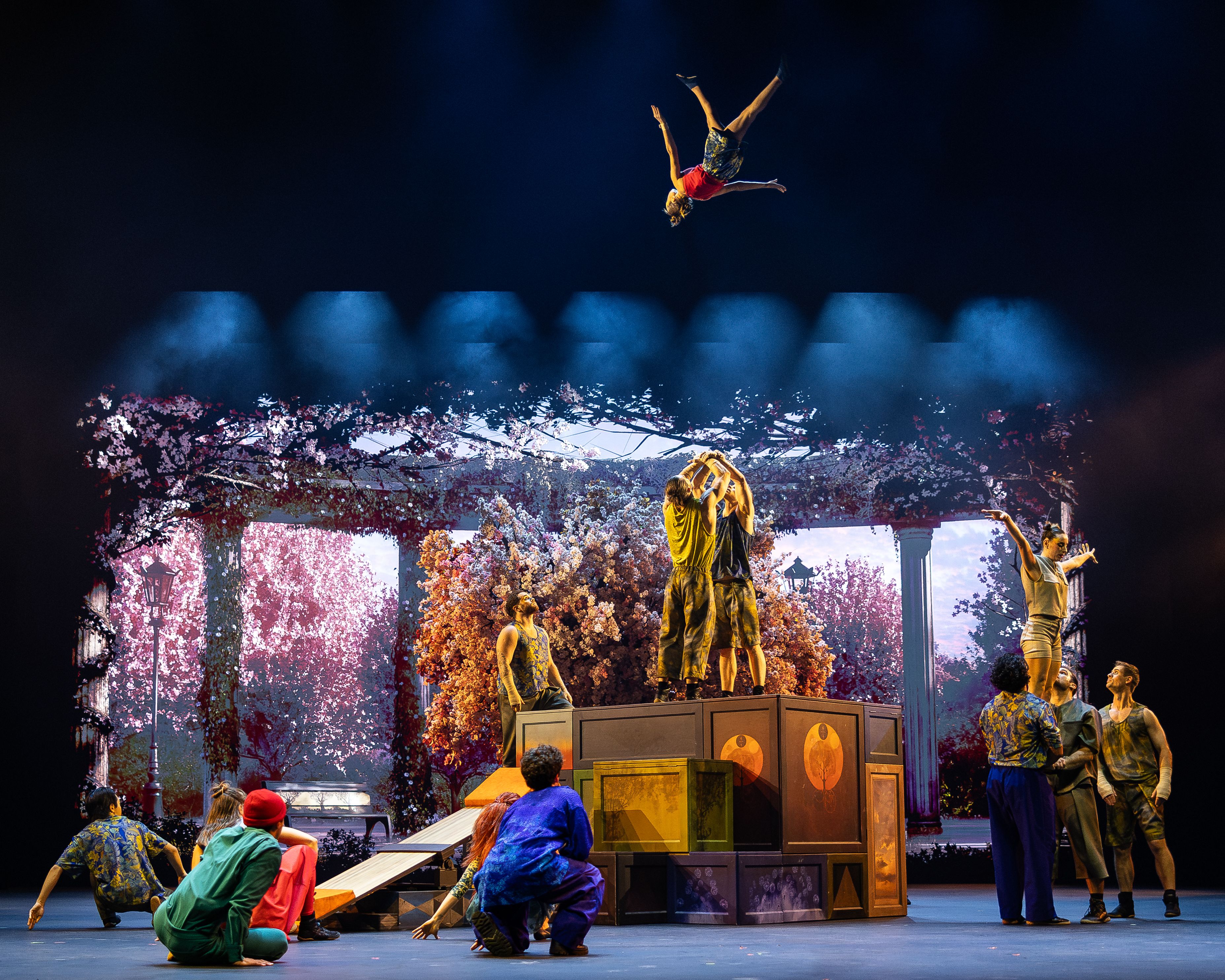 Szenenbild mehrere Artisten führen akrobatische Kunststücke auf der Bühne auf