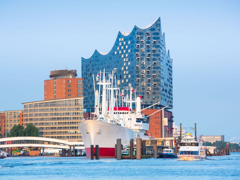 Schiff mit Masten neben Booten im Hamburger Hafen vor der Elbphilharmonie