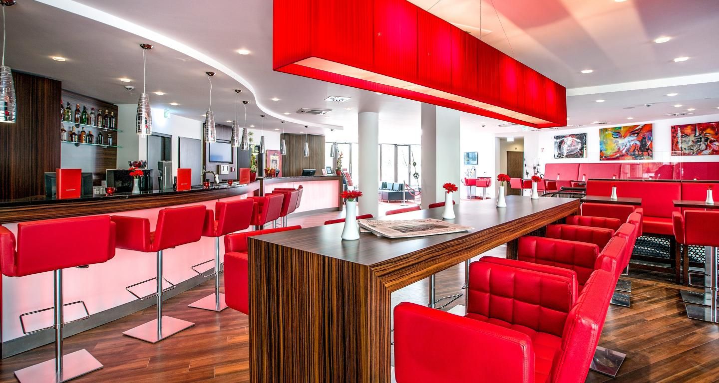 Restaurant und Bar mit roten Stühlen und Barhockern in einem Best Western Hotel