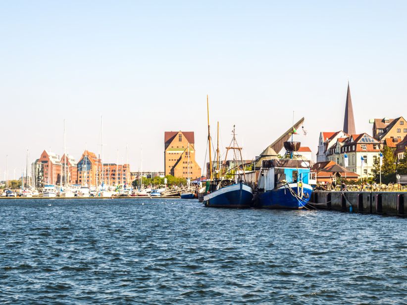 Hafen von Rostock mit festgemachten Booten und Blick auf das offene Wasser der Ostsee.