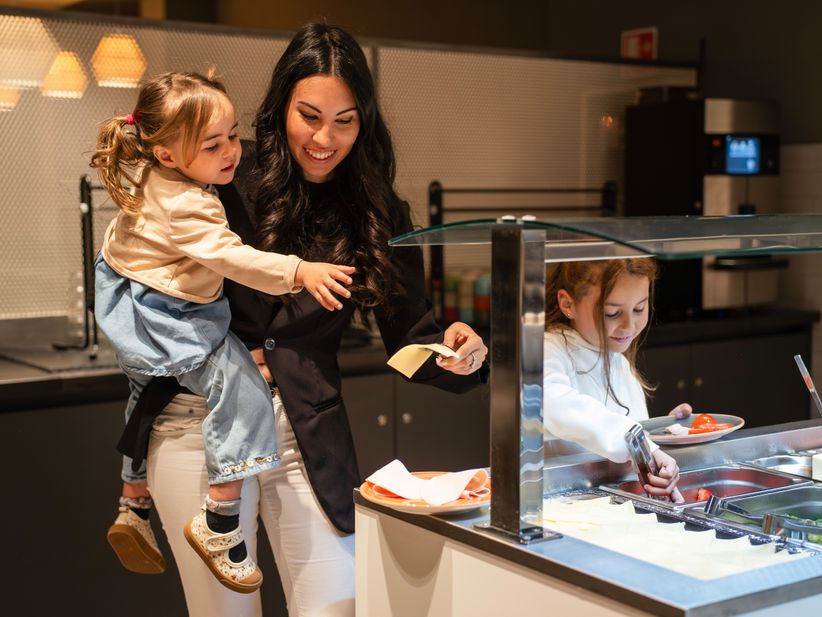 Mutter und Töchter am Frühstücksbuffet in einem a&o Hostel