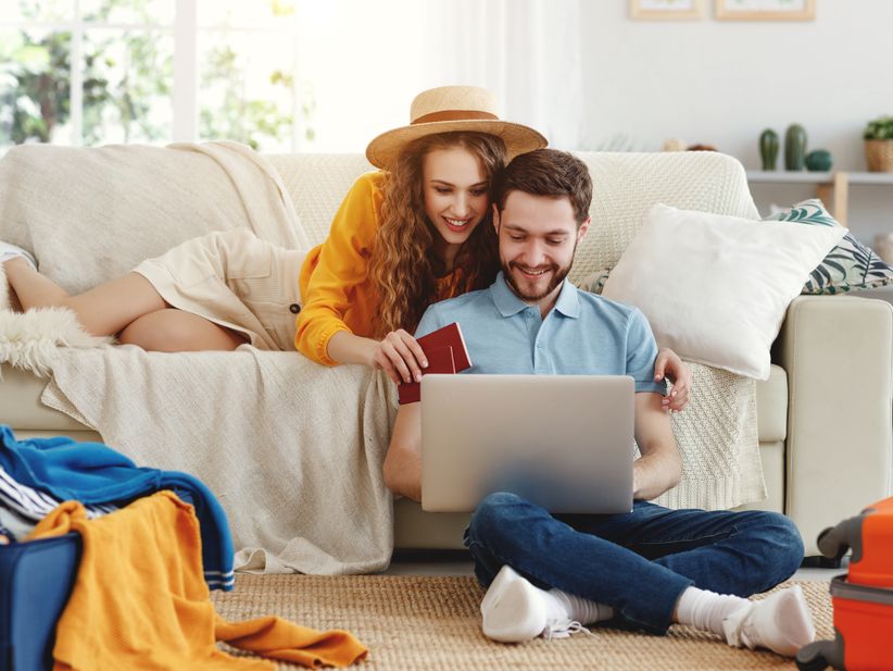 „Paar wählt Flug über Laptop im Wohnzimmer