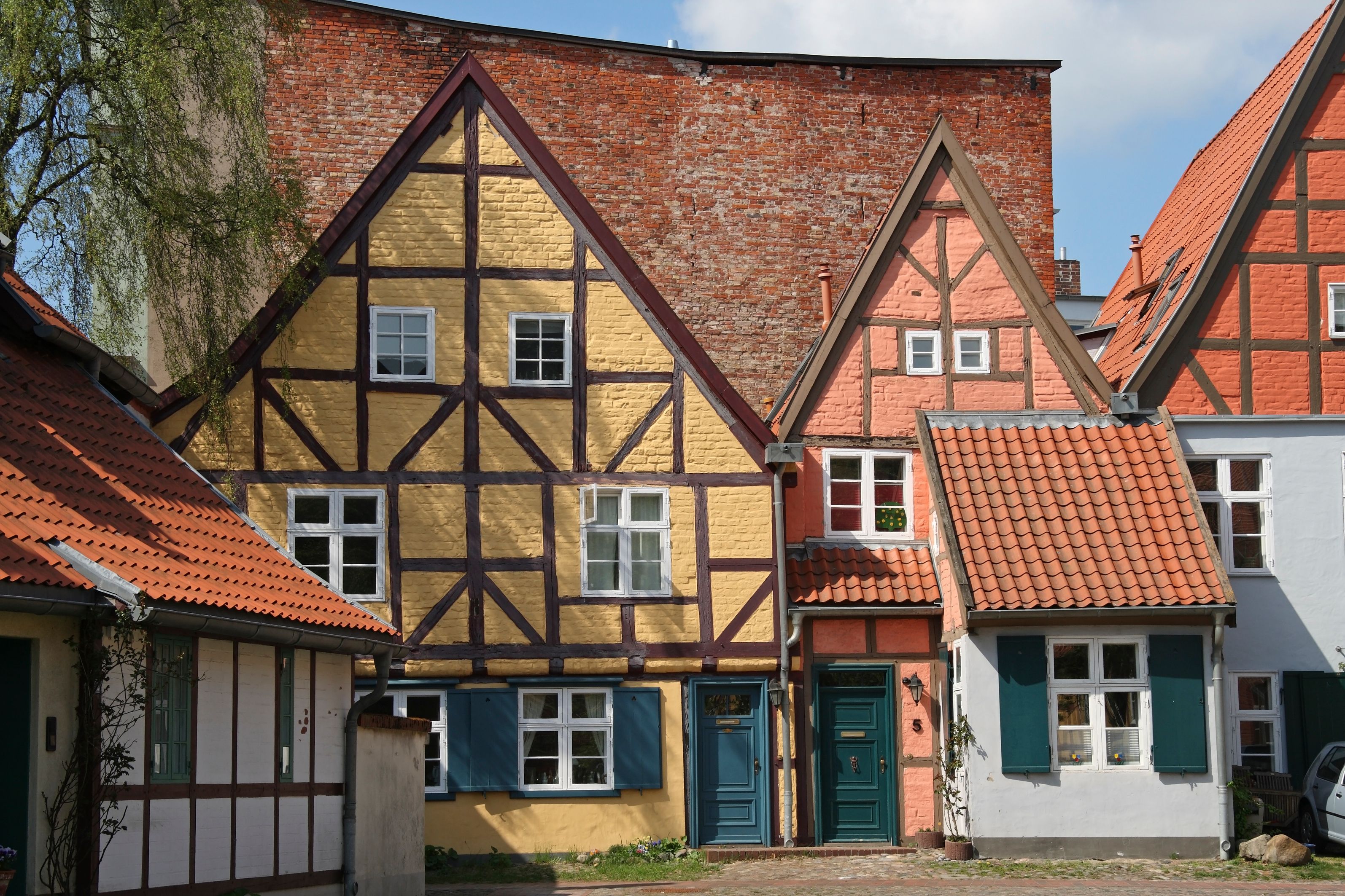 Historisches Fachwerkhaus in Stralsund mit verzierten Holzbalken und farbiger Fassade.