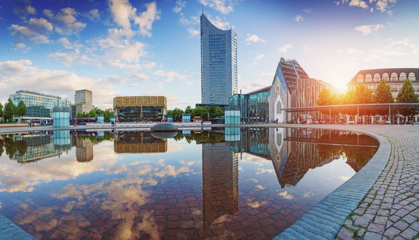 Gebäude spiegeln sich im Wasser am Augustusplatz in Leipzig