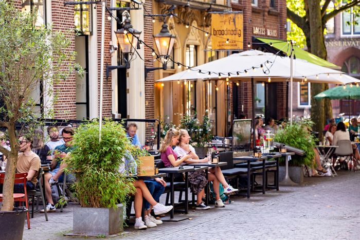 Menschen sitzen draußen im Cafe in der Mariaplaats in Utrecht