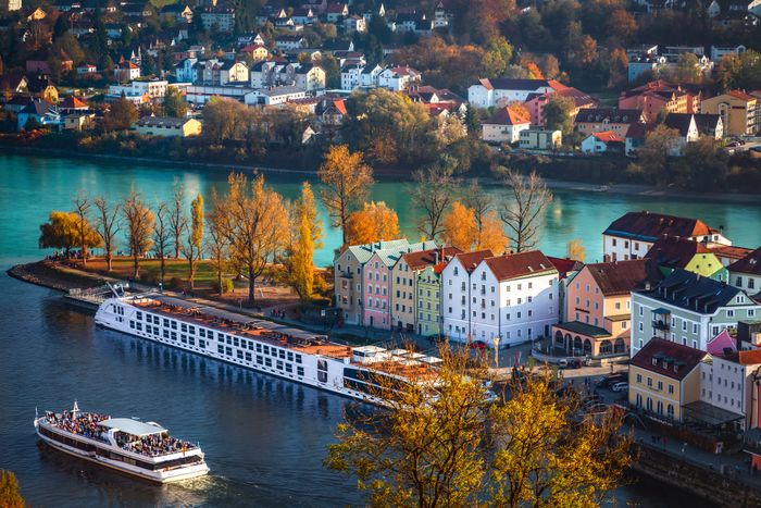 Panoramablick auf Passau mit einem Donaukreuzfahrtschiff und einem Fahrgastschiff auf der Donau.
