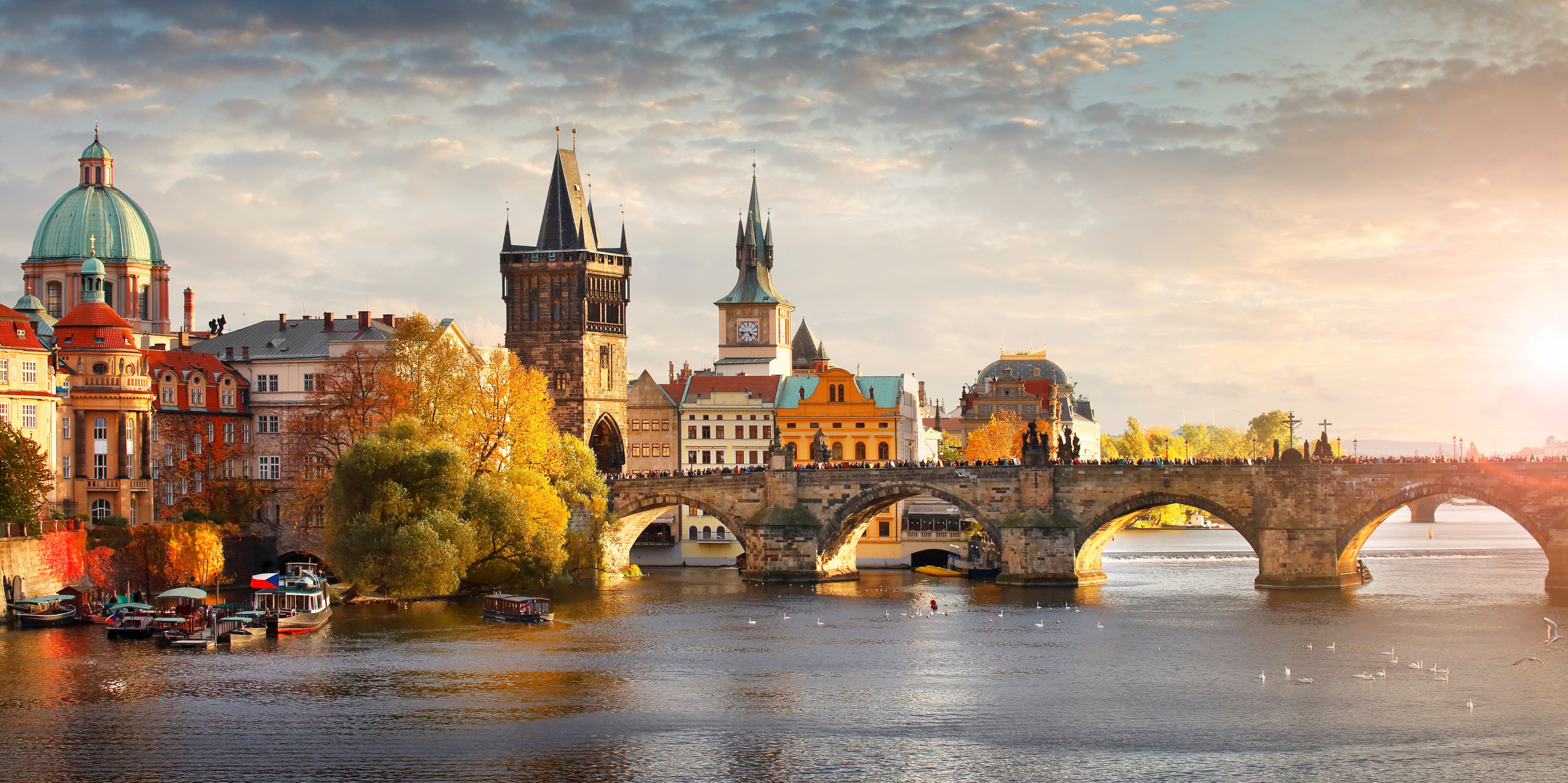 Panoramablick auf die Karlsbrücke in Prag im Herbst, mit buntem Laub und Blick auf die Moldau.