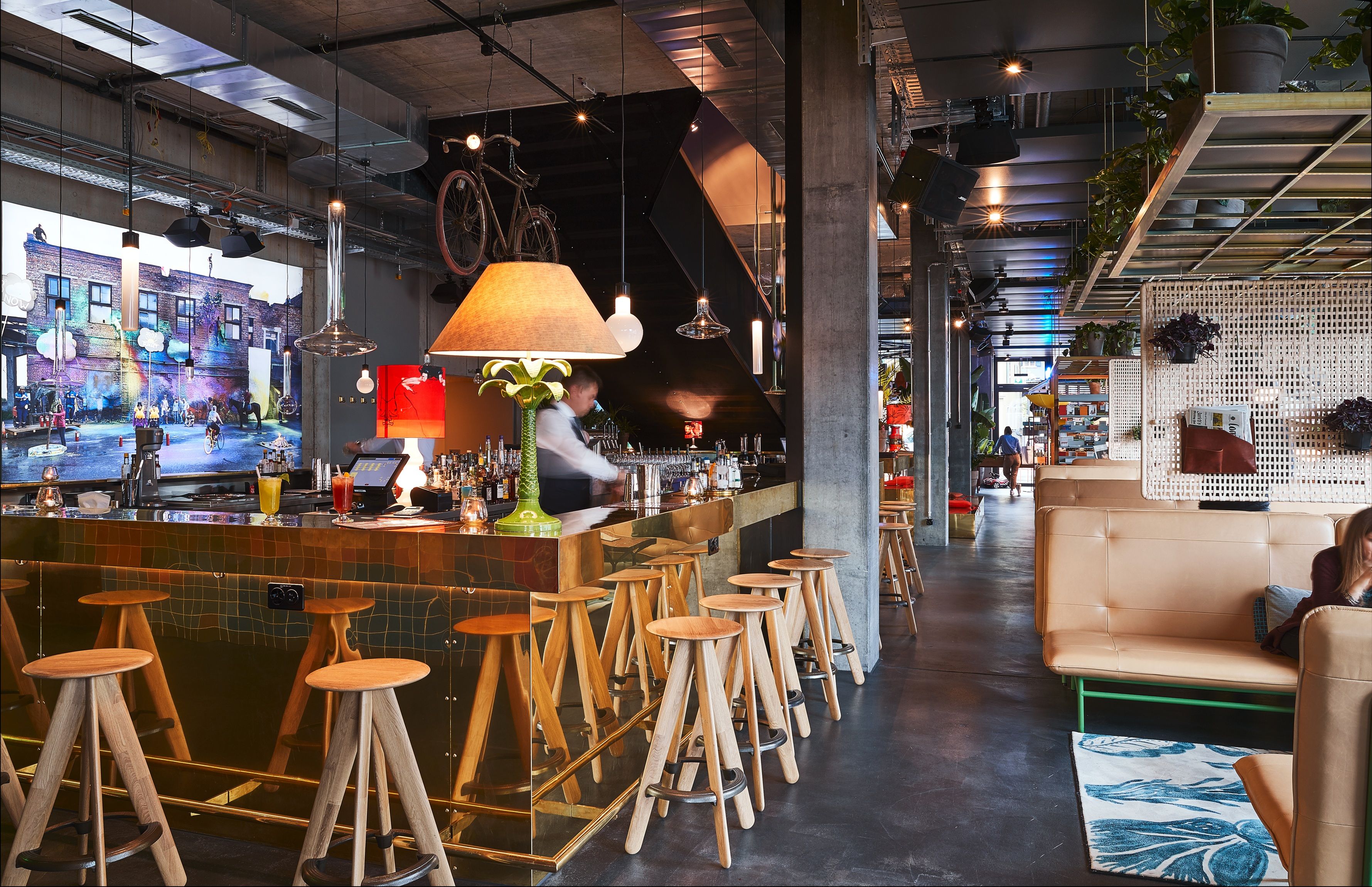 Industriell gestaltete Bar mit Holzstühlen und Ledersitzflächen im 25hours IndreBy Hotel